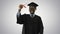 Happy african american male student in graduation robe walking t