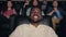 Happy African American man laughing in cinema watching funny comedy