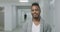 Happy African American man stands in hospital corridor