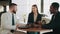 Happy african american man using credit card for payment while buying new car. Multiracial couple sitting with salesman