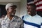 Happy african american military senior man looking at smiling mid adult son against house