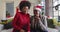 Happy african american mother and adult daughter in santa hats on christmas video call, slow motion