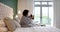 Happy african american mother combing daughter hair sitting on bed in bedroom, slow motion