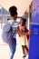 Happy african american schoolchildren standing next to locker at school