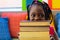 Happy african american schoolgirl holding books in colourful room at elementary school