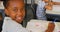 Happy African-American schoolgirl studying at desk in a classroom at school 4k