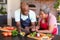 Happy african american senior couple cooking together in kitchen, using tablet