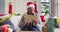 Happy african american senior woman in christmas santa hat making tablet video call, slow motion
