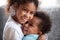 Happy African American siblings embracing, sitting together