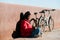 happy african-american woman with bike sitting on street and writing in a notebook