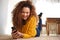 Happy african american woman lying on floor looking at mobile phone