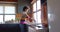 Happy african american woman rinsing vegetables in sunny kitchen, in slow motion