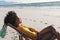 Happy african american woman in sunglasses relaxing in deckchair on sunny beach by sea