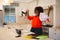 Happy african american woman working in kitchen with laptop, celebrating success, throwing papers