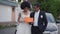 Happy African American young couple standing at car holding Just married sign talking smiling. Joyful newlyweds at