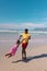 Happy african american young man holding daughter\\\'s hands and spinning her at beach against blue sky