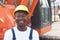 Happy african construction worker with red excavator