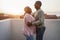 Happy african couple dancing outdoors at sunset - Soft focus on man face