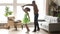 Happy african dad dancing with child daughter in living room