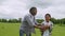 Happy african dad and school boy walking on field to play american football