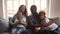 Happy african family with children wave hands looking at camera