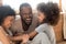 Happy african family with kid daughter tickling laughing together