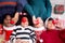 Happy African family lying holding heart shape on Christmas day together while gift box on floor.