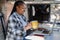 Happy african having fun woman using computer laptop inside mini camper van - Focus on face