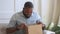 Happy african man customer open parcel box satisfied with purchase