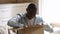 Happy african man customer open parcel cardboard box at home