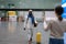 Happy african man employee with luggage going to female waiting for him with sign board in airport