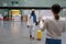 Happy african man employee with luggage going to female waiting for him with sign board in airport