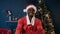Happy african man in santa claus costume holding the gift on the Christmas tree background.
