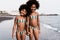 Happy african sister twins running on the beach together - Focus on faces