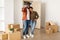 Happy African Spouses Showing Key Standing Among Moving Boxes Indoor