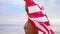 Happy african woman with american flag on beach