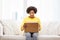 Happy african young woman with parcel box at home