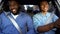 Happy afro-american father and teen sitting in car, dad pleased with sons drive