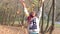 The happy afro-american teenager throwing the yellowed leaves in the park.