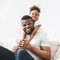 Happy afro family of two hugging at home