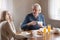 Happy aged husband and wife enjoy breakfast at home