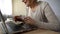 Happy aged lady typing message on laptop, communicating on dating website