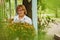 Happy aged woman enjoying tea on blooming terrace