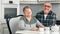 Happy aging couple laughing posing during breakfast at kitchen feeling love looking at camera