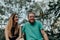 Happy alternative couple laughing together while sitting in nature