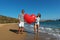 Happy amorous couple on the beach with a big heart balloon. Summer love concept