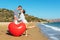 Happy amorous couple on the beach with a big heart balloon. Summer love concept