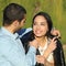 Happy arab couple flirting while man cover her with his jacket in a park