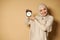 Happy arab woman with covered head in hijab holding alarm clock in hands and smiling cute with toothy smile at camera