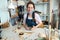 Happy artist woman molding with clay at pottery workshop - Focus on face